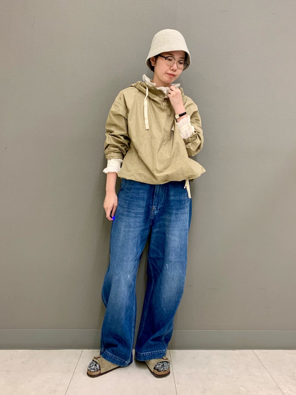 ブルー系のデニムパンツ、ベージュ系のTシャツ/カットソー、ホワイト系のシャツ/ブラウスを着用したレディースの秋コーディネートの3枚目の写真