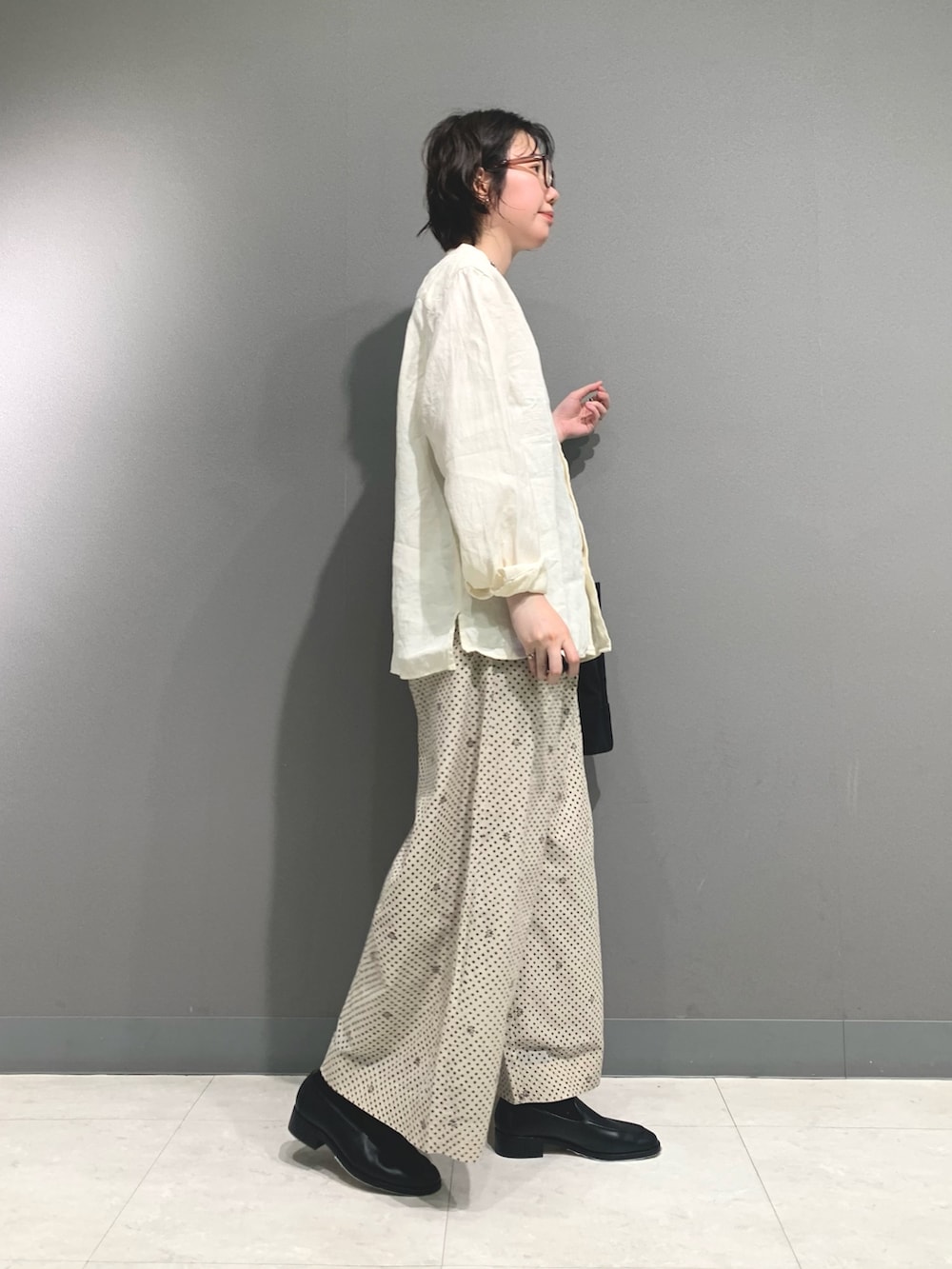 ホワイト系のシャツ/ブラウス、ベージュ系のその他パンツ、ブラック系のトートバッグを着用したレディースの春コーディネートの3枚目の写真