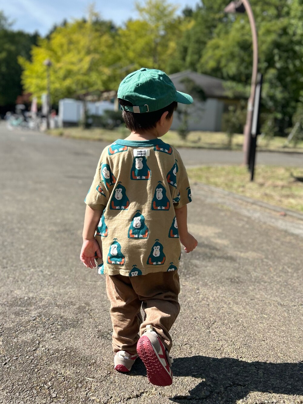 ベージュ系のTシャツ/カットソー、ブラウン系のパンツ、レッド系のスニーカーを着用したキッズの秋コーディネートの2枚目の写真