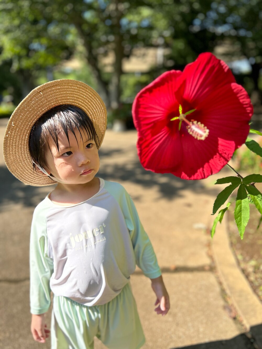 ベージュ系の帽子、グリーン系のラッシュガードを着用したキッズの夏コーディネートの3枚目の写真