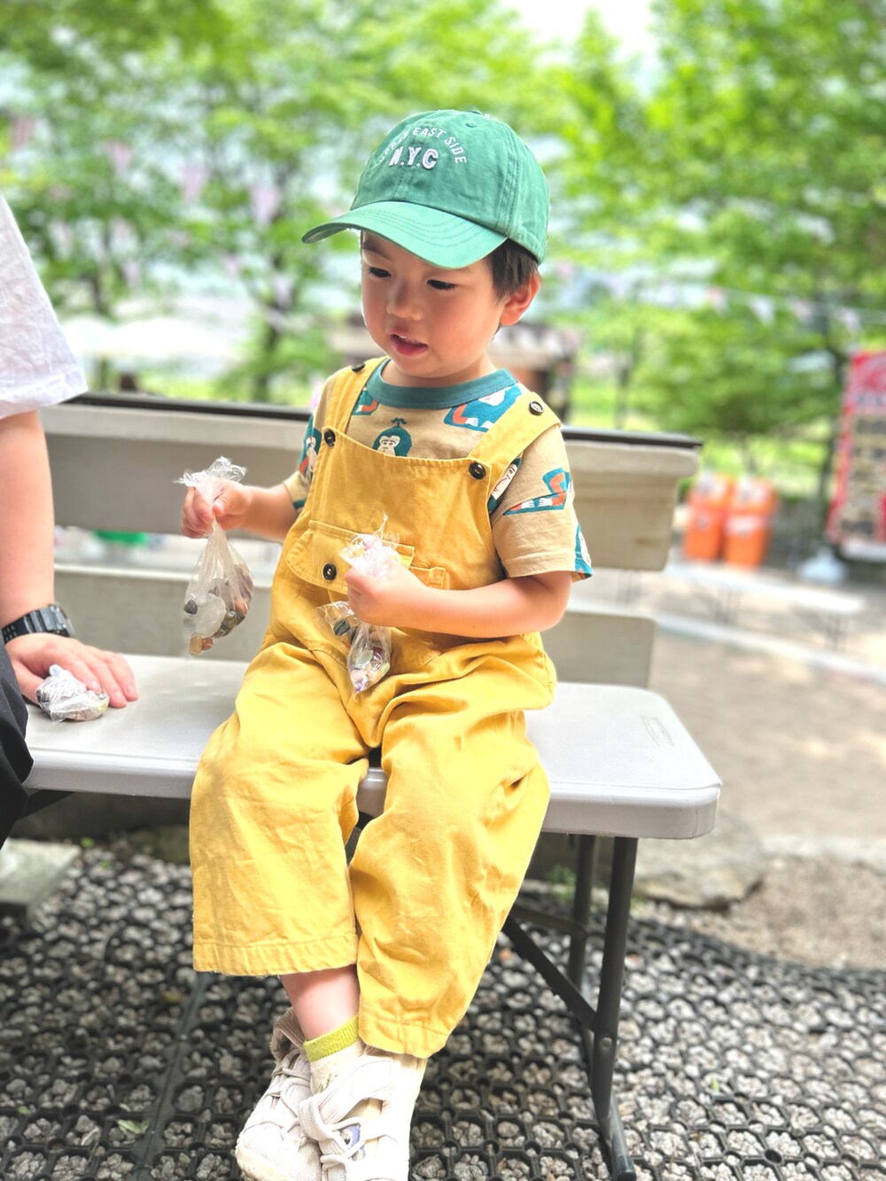 イエロー系のサロペット/オーバーオール、ベージュ系のTシャツ/カットソー、ベージュ系のサンダルを着用したキッズの夏コーディネートの2枚目の写真