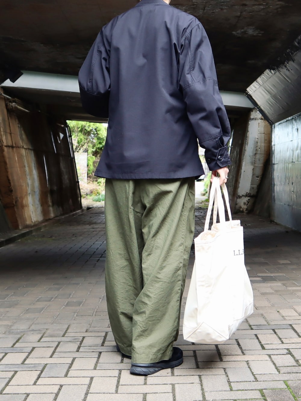 ブラック系のジャケット/アウター、ブラック系のトップス、グリーン系のパンツを着用したメンズの秋コーディネートの3枚目の写真