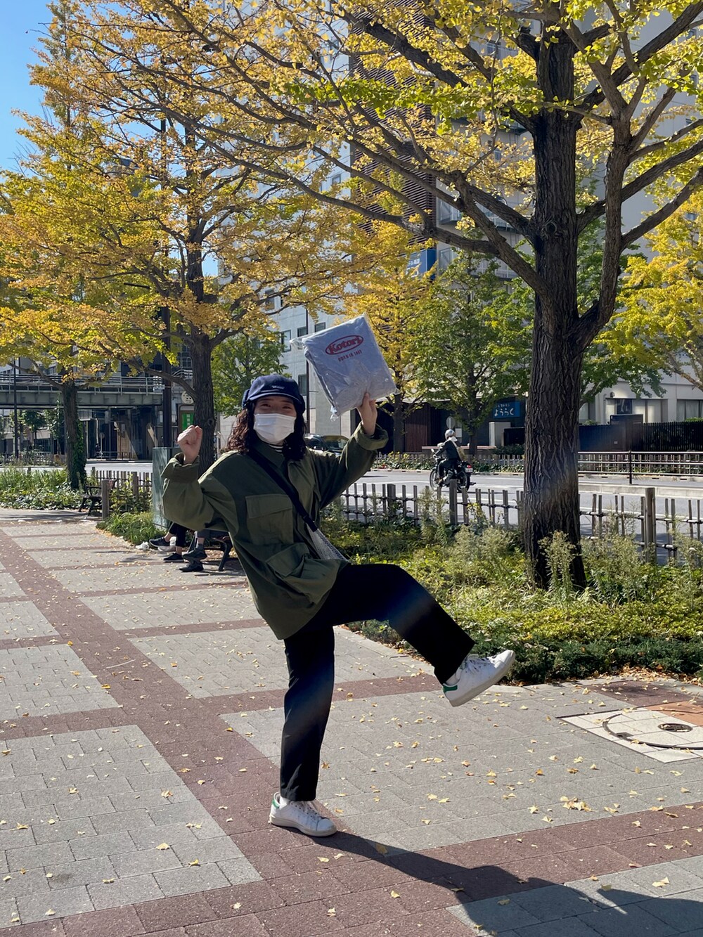 ブラック系のパンツ、ホワイト系のスニーカー、グリーン系のジャケット/アウターを着用したレディースの秋コーディネートの2枚目の写真