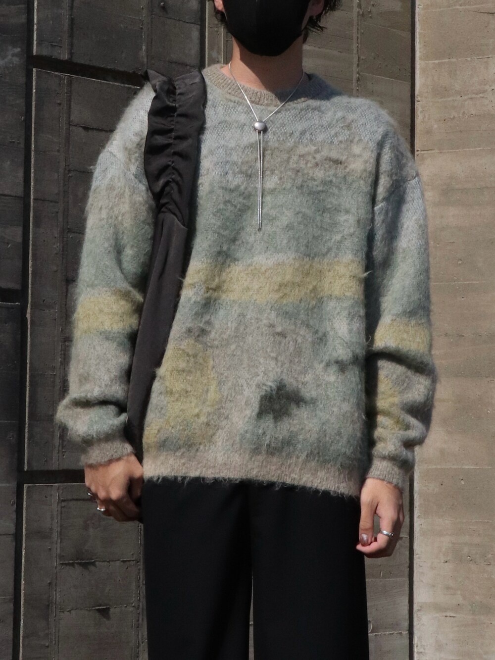 ホワイト系のニット/セーター、ブラック系のショルダーバッグ、ブラック系のスラックスを着用したメンズの秋コーディネートの2枚目の写真