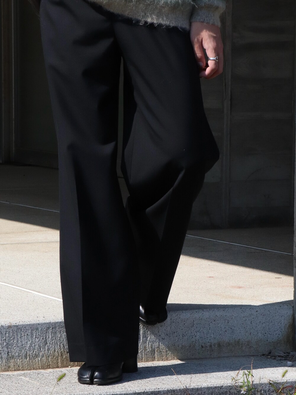 ホワイト系のニット/セーター、ブラック系のショルダーバッグ、ブラック系のスラックスを着用したメンズの秋コーディネートの5枚目の写真