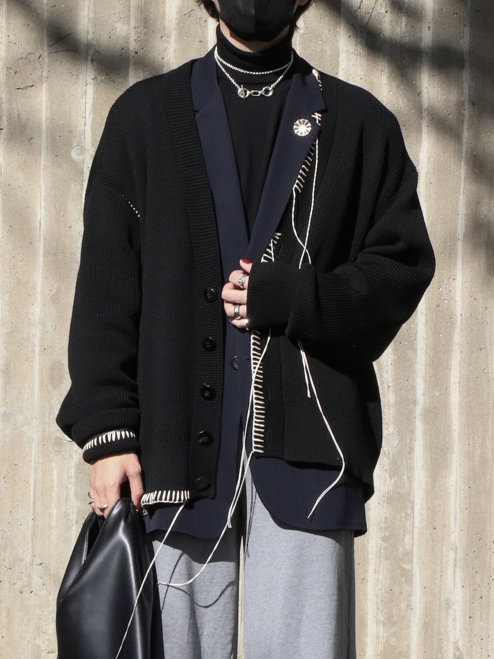 ブラック系のニット/セーター、ブルー系のテーラードジャケット、ブラック系のカーディガン/ボレロを着用したメンズの冬コーディネートの3枚目の写真