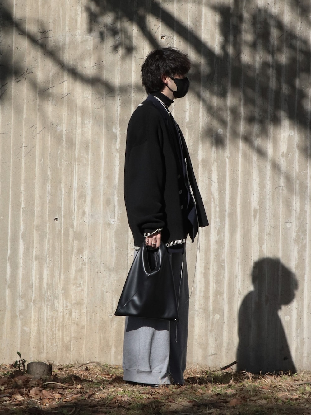 ブラック系のニット/セーター、ブルー系のテーラードジャケット、ブラック系のカーディガン/ボレロを着用したメンズの冬コーディネートの2枚目の写真