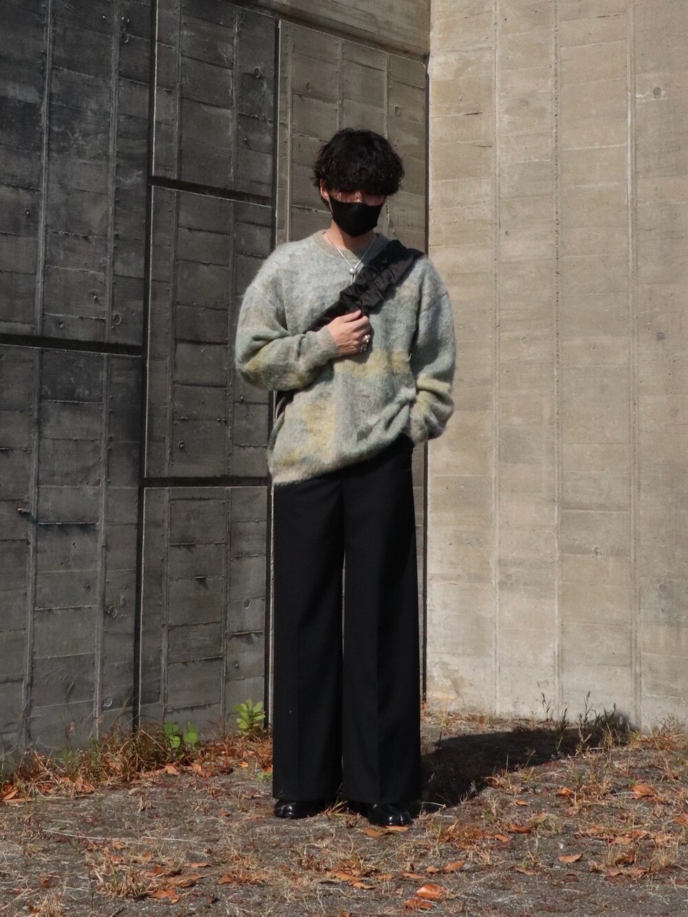 ホワイト系のニット/セーター、ブラック系のショルダーバッグ、ブラック系のスラックスを着用したメンズの秋コーディネートの4枚目の写真