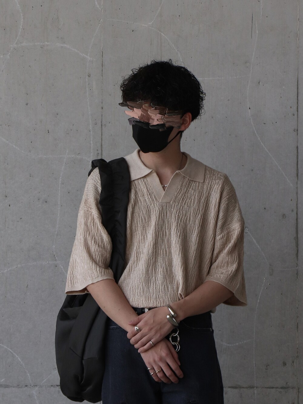 ベージュ系のトップス、ブラック系のデニムパンツ、ブルー系のトップスを着用したメンズの春コーディネートの4枚目の写真