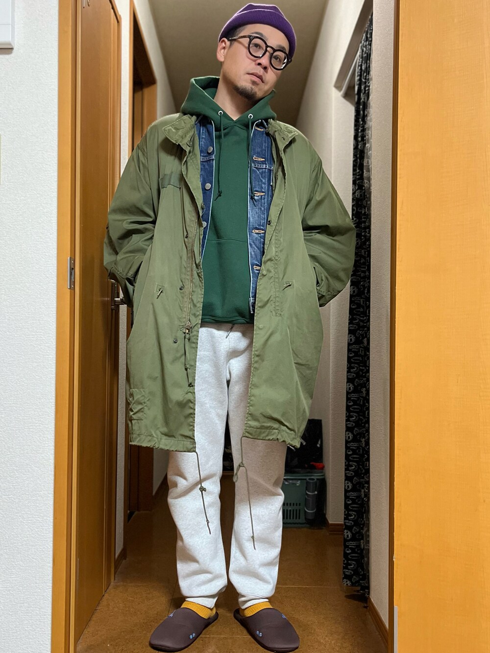 グリーン系のミリタリージャケット、グレー系のスウェットパンツ、ブルー系のデニムジャケットを着用したメンズの冬コーディネートの2枚目の写真