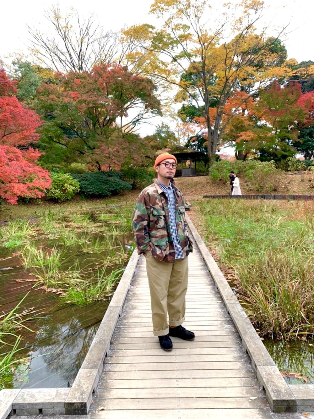 グリーン系のミリタリージャケット、ベージュ系のチノパンツ、ブラック系のブーツを着用したメンズの秋コーディネートの2枚目の写真