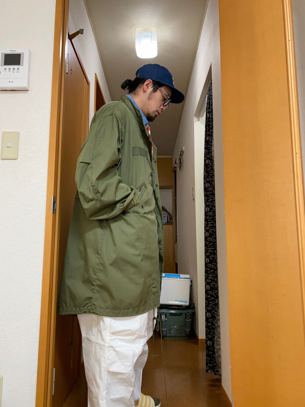 グリーン系のミリタリージャケット、ブルー系のシャツ/ブラウス、ホワイト系のパンツを着用したメンズの冬コーディネートの3枚目の写真