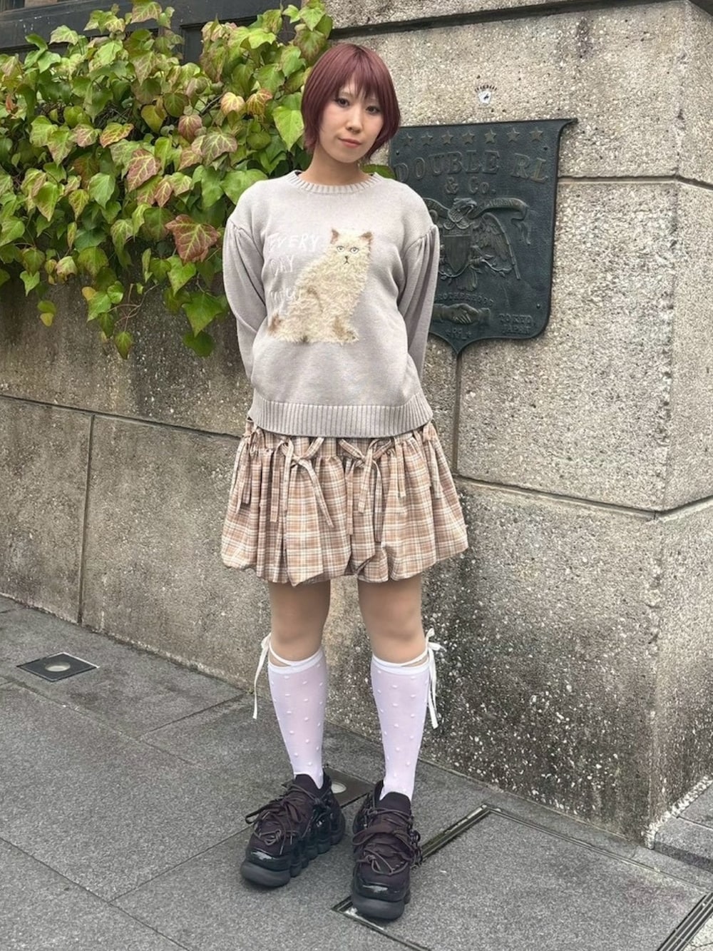 グレー系のニット/セーター、ベージュ系のスカート、ホワイト系のソックス/靴下を着用したレディースの秋コーディネートの3枚目の写真