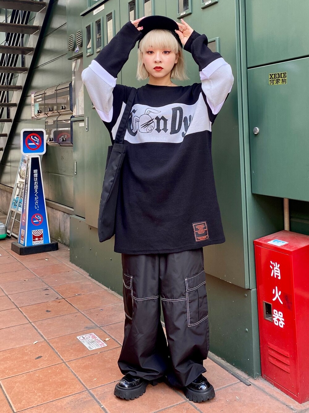 ブラック系のTシャツ/カットソー、ブラック系のカーゴパンツ、ブラック系のトートバッグを着用したレディースの夏コーディネートの2枚目の写真