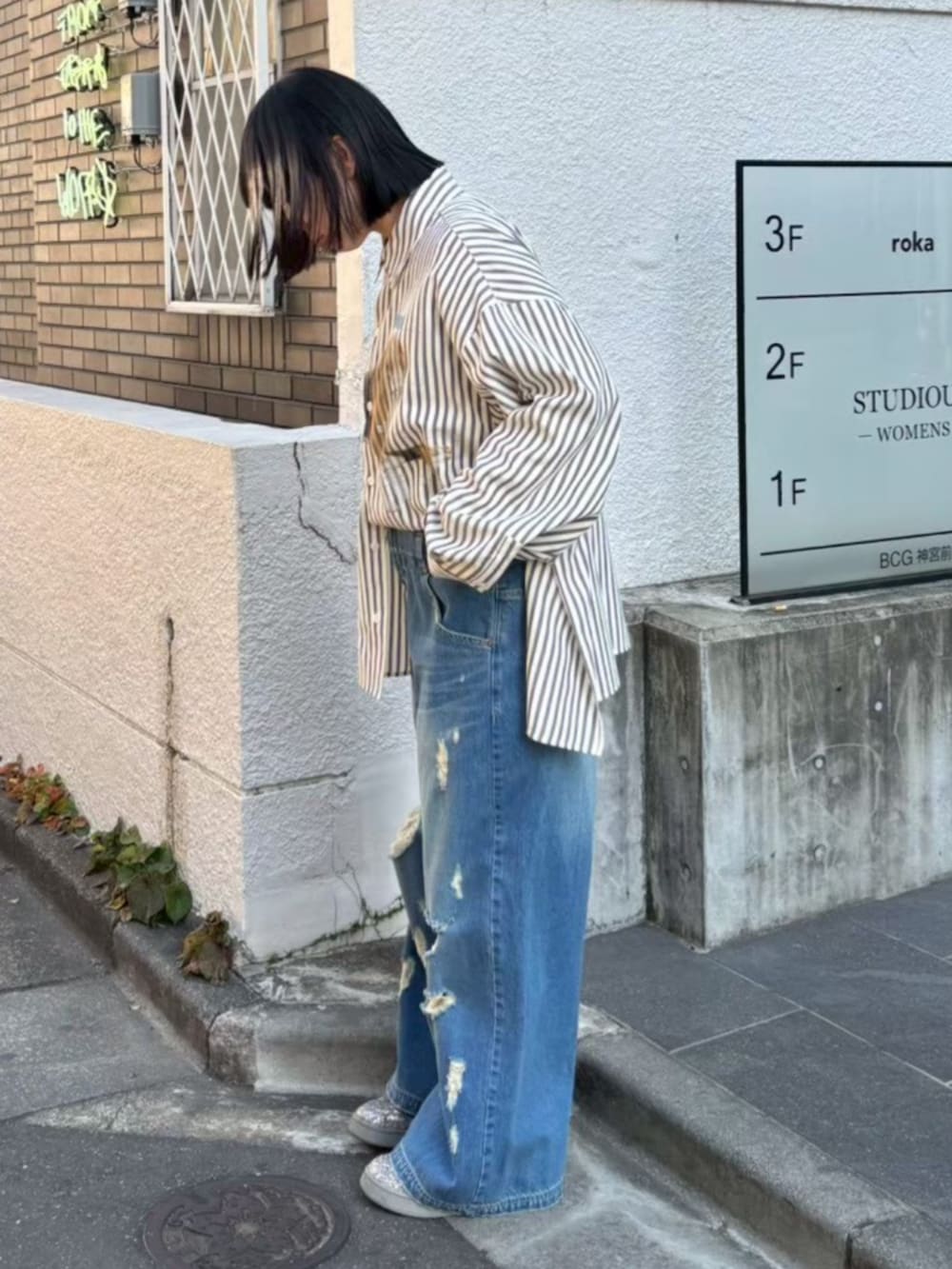 グレー系のシャツ/ブラウス、ブルー系のデニムパンツを着用したレディースの冬コーディネートの2枚目の写真