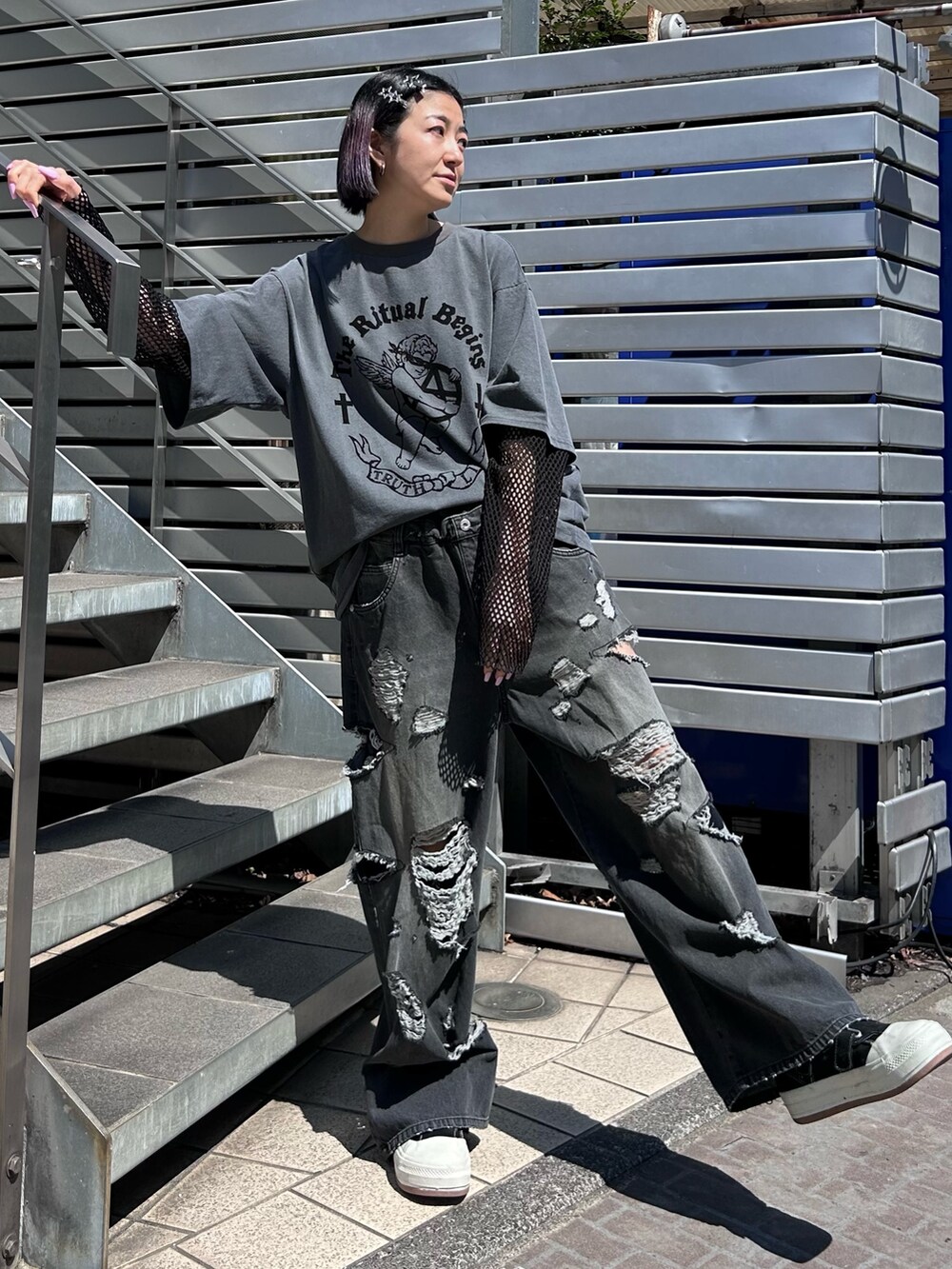 ブラック系のショルダーバッグ、ブラック系のデニムパンツ、グレー系のTシャツ/カットソーを着用したレディースの春コーディネートの2枚目の写真