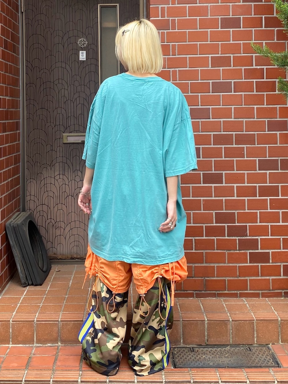 ベージュ系のその他パンツ、オレンジ系のその他パンツ、ホワイト系のTシャツ/カットソーを着用したレディースの春コーディネートの5枚目の写真