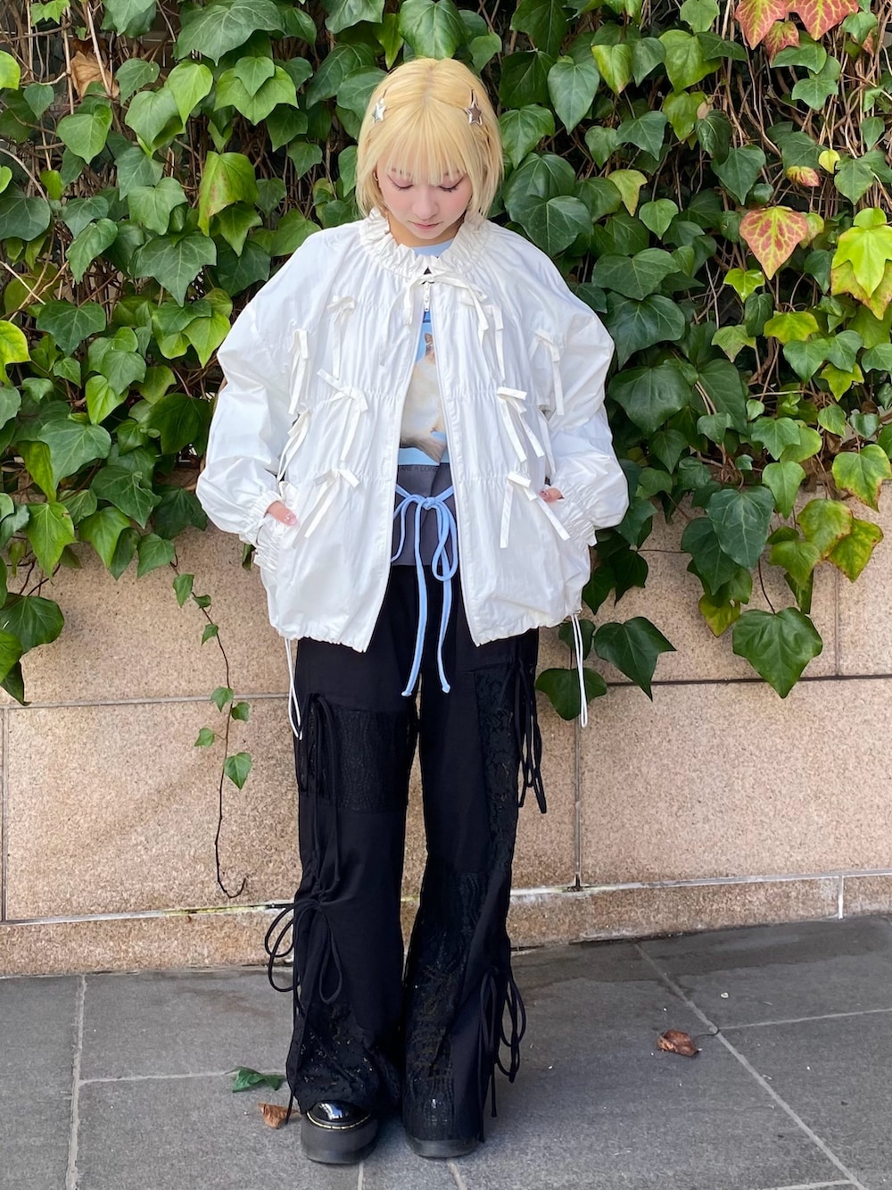 ホワイト系のブルゾン、グレー系のTシャツ/カットソー、ブラック系のその他パンツを着用したレディースの冬コーディネートの2枚目の写真