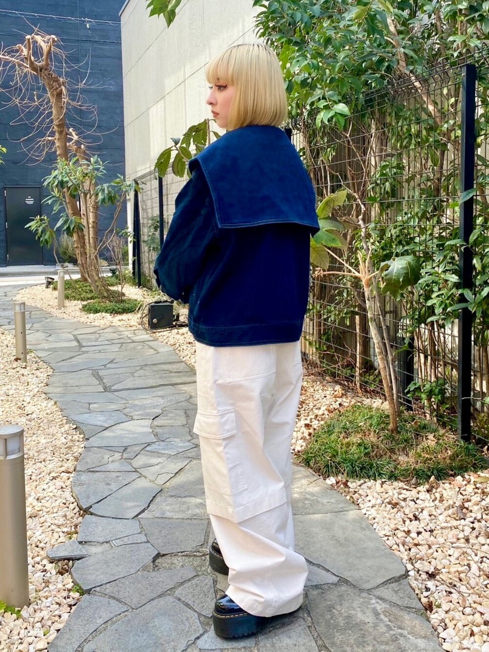 ホワイト系のカーゴパンツ、イエロー系のポロシャツ、ブルー系のデニムジャケットを着用したレディースの春コーディネートの4枚目の写真