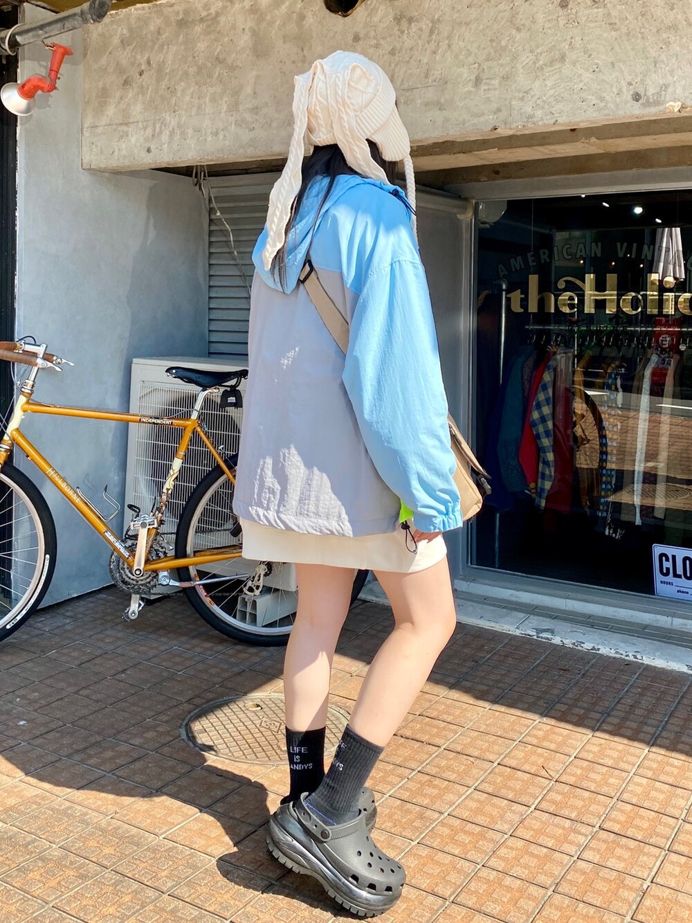 ブルー系のナイロンジャケット、ホワイト系のスウェット、ベージュ系のショルダーバッグを着用したレディースの秋コーディネートの4枚目の写真