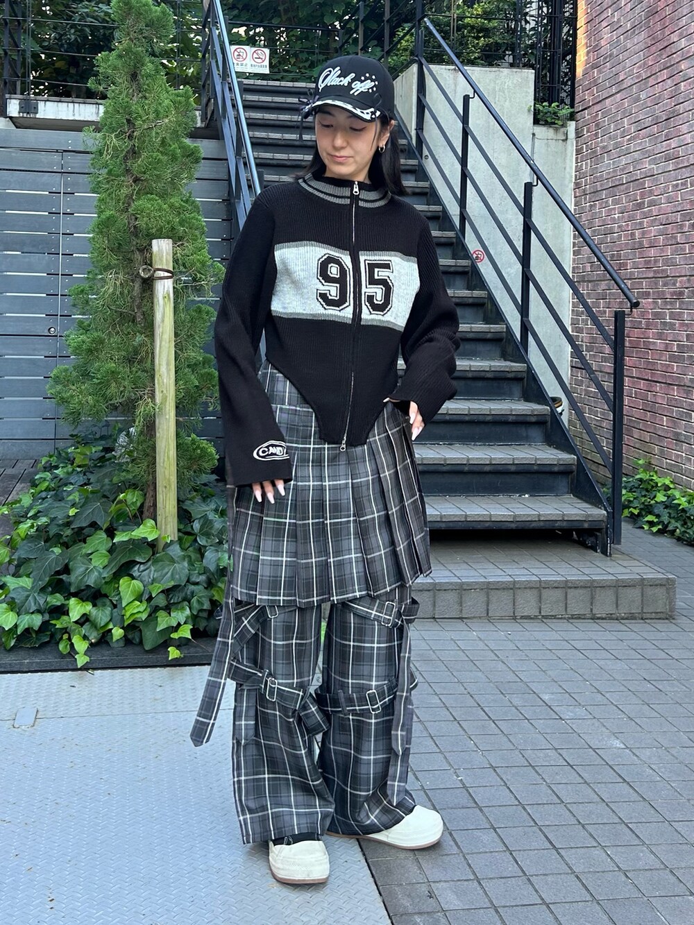 グレー系のその他パンツ、ブラック系のニット/セーター、ブラック系のキャップを着用したレディースの秋コーディネートの4枚目の写真