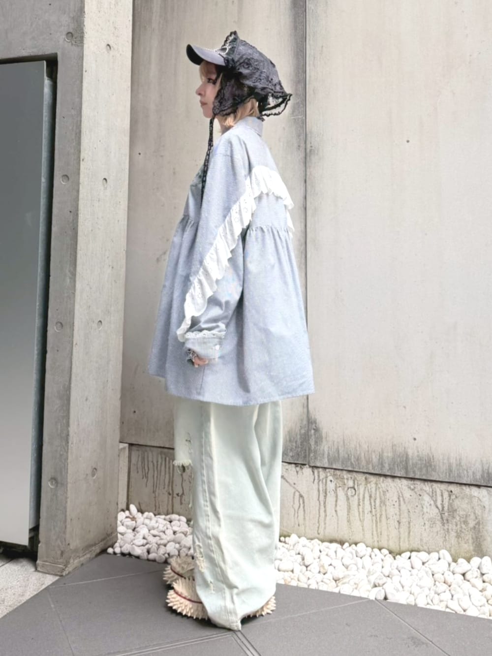 ブルー系のデニムパンツ、ブラック系のシャツワンピース、ブラック系のキャップを着用したレディースの春コーディネートの4枚目の写真