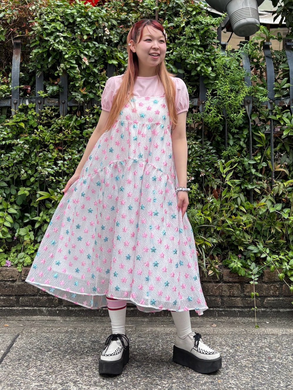 ピンク系のワンピース、ピンク系のTシャツ/カットソー、ブラック系のショルダーバッグを着用したレディースの夏コーディネートの3枚目の写真