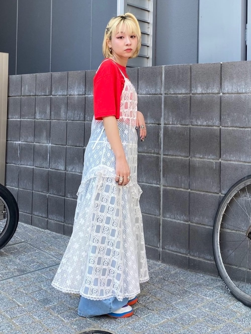 ブルー系のデニムパンツ、ホワイト系のワンピース、レッド系のTシャツ/カットソーを着用したレディースの夏コーディネートの4枚目の写真