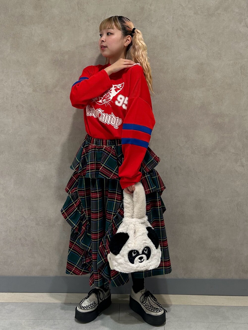 ホワイト系のハンドバッグ、グリーン系のスカート、レッド系のTシャツ/カットソーを着用したレディースの秋コーディネートの3枚目の写真