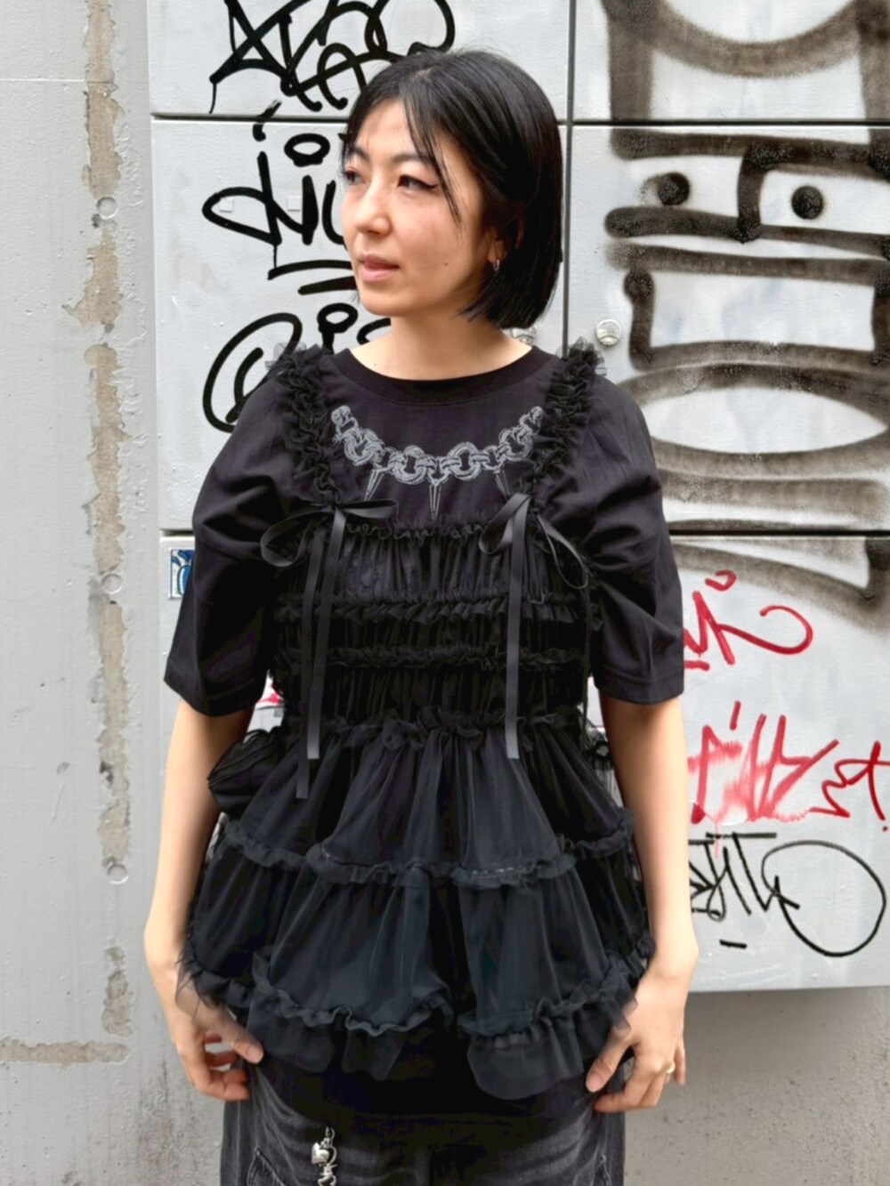 ブラック系のデニムパンツ、ブラック系のTシャツ/カットソー、ブラック系のその他トップスを着用したレディースの春コーディネートの4枚目の写真
