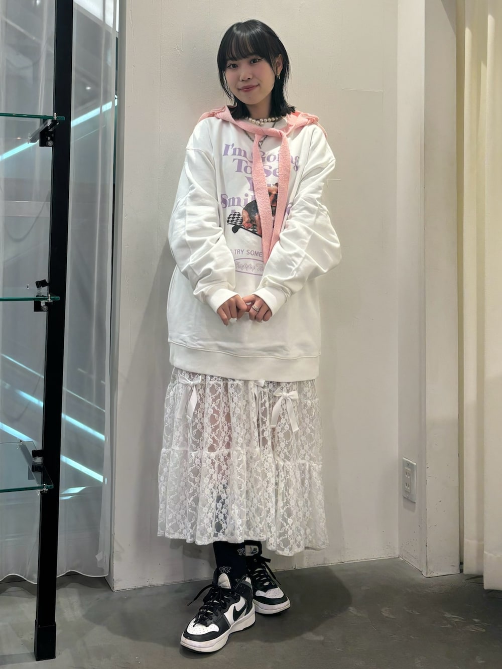 ホワイト系のシューズ、ホワイト系のスウェット、ピンク系のワンピースを着用したレディースの秋コーディネートの4枚目の写真