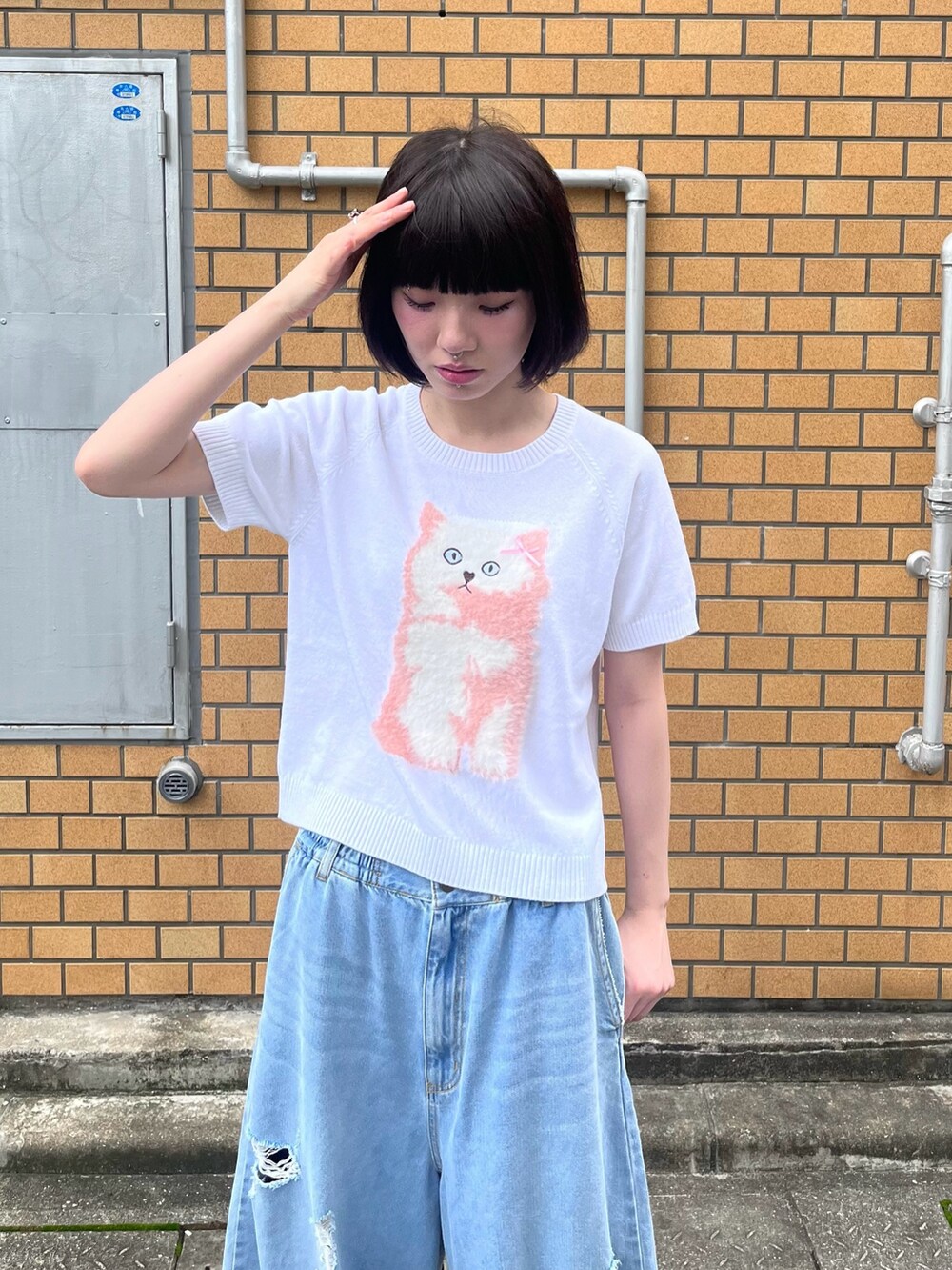 ブルー系のデニムパンツ、ホワイト系のニット/セーターを着用したレディースの夏コーディネートの5枚目の写真