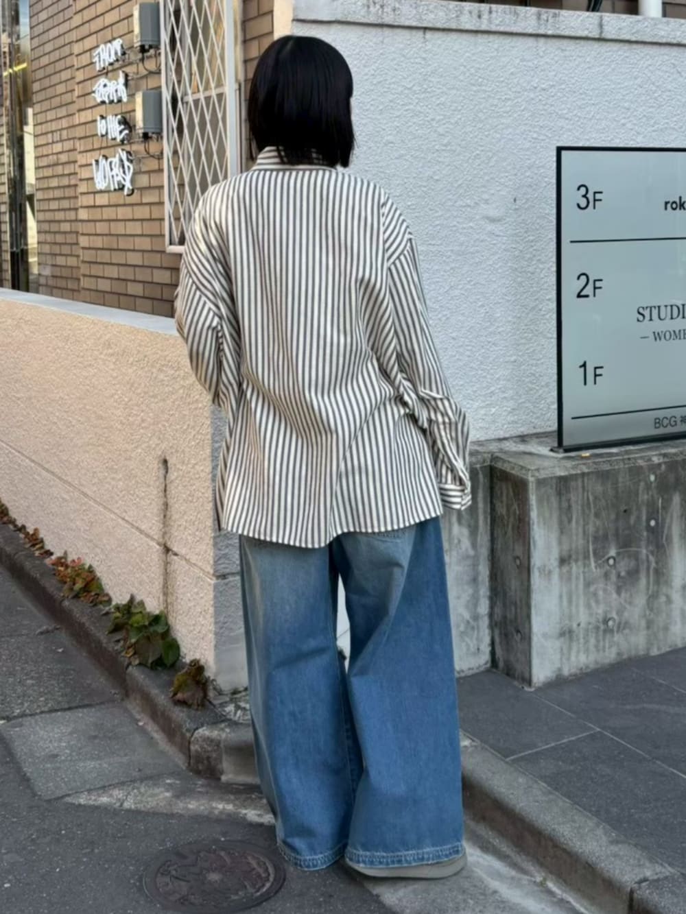 グレー系のシャツ/ブラウス、ブルー系のデニムパンツを着用したレディースの冬コーディネートの3枚目の写真