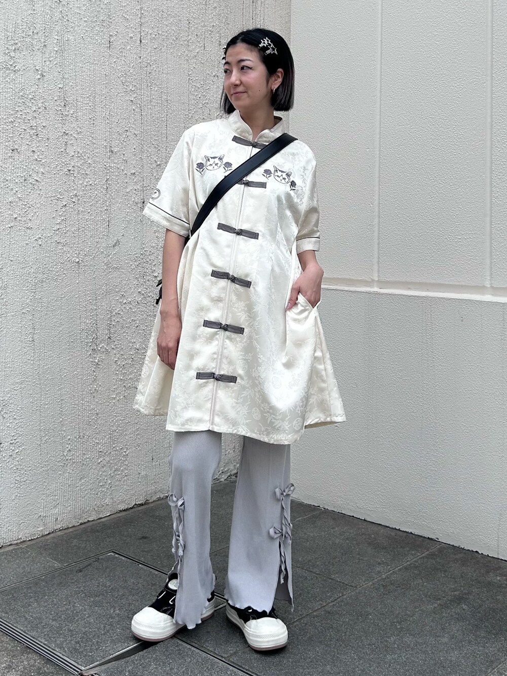 ブラック系のショルダーバッグ、グレー系のその他パンツ、ホワイト系のワンピースを着用したレディースの春コーディネートの2枚目の写真