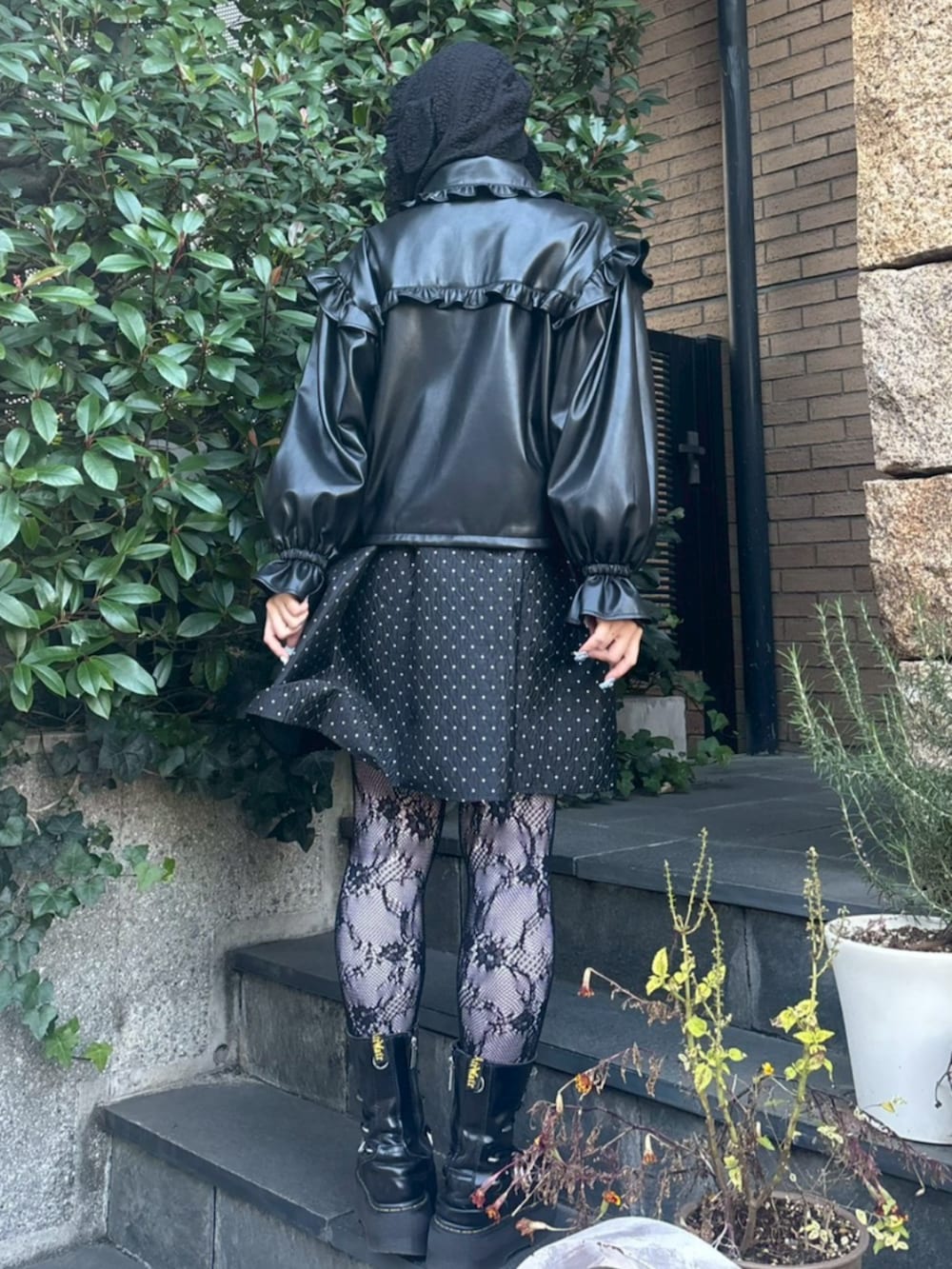 ブラック系のワンピース、ブラック系のライダースジャケット、ホワイト系のTシャツ/カットソーを着用したレディースの冬コーディネートの3枚目の写真