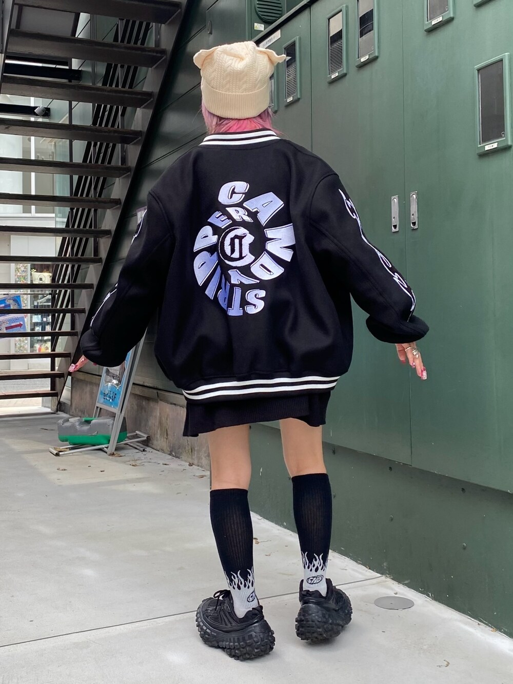 ブラック系のスタジャン、ブラック系のニット/セーター、ホワイト系のニットキャップ/ビーニーを着用したレディースの秋コーディネートの3枚目の写真