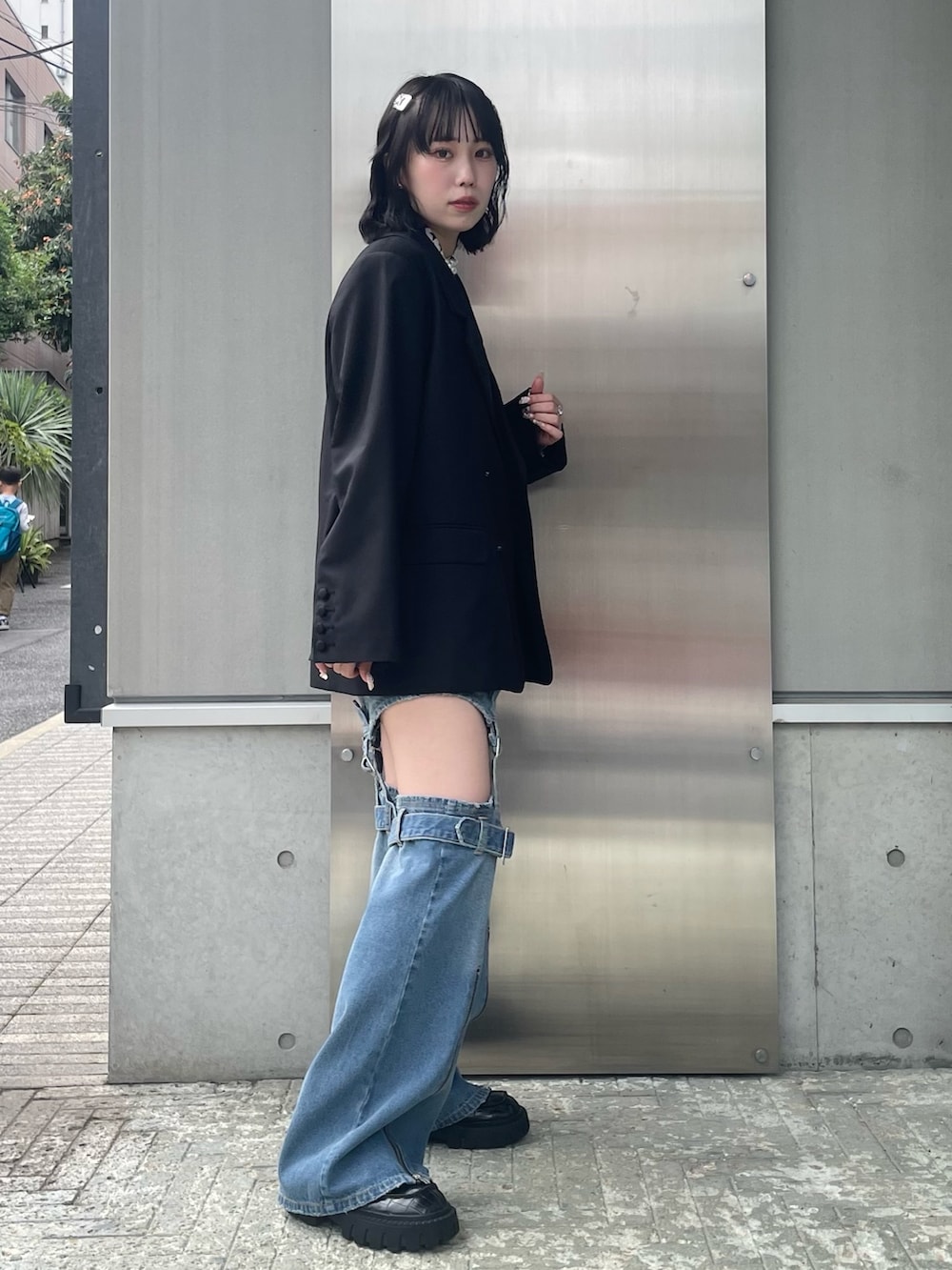 ブラック系のテーラードジャケット、ホワイト系のその他トップス、ブルー系のデニムパンツを着用したレディースの秋コーディネートの3枚目の写真