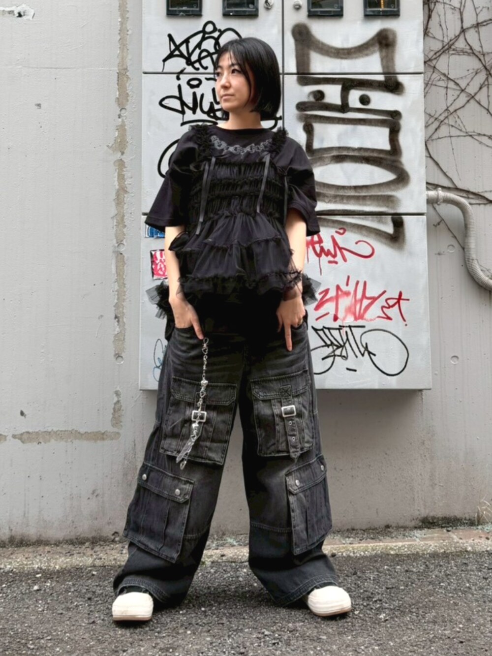 ブラック系のデニムパンツ、ブラック系のTシャツ/カットソー、ブラック系のその他トップスを着用したレディースの春コーディネートの3枚目の写真