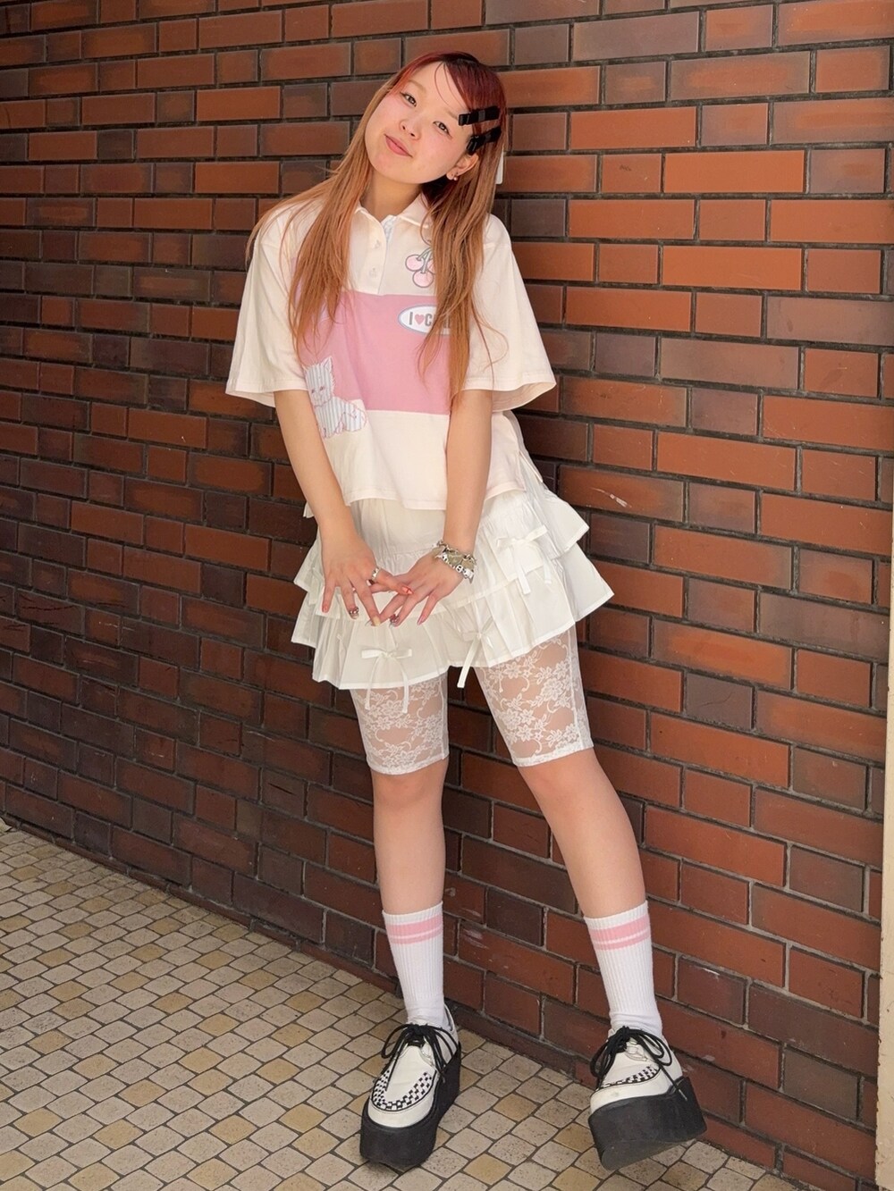 ピンク系のポロシャツ、ホワイト系のその他パンツを着用したレディースの夏コーディネートの2枚目の写真