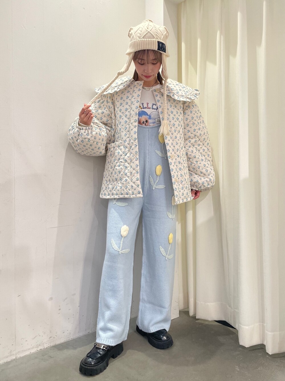 ホワイト系のダウンジャケット/コート、ホワイト系のTシャツ/カットソー、ブルー系のサロペット/オーバーオールを着用したレディースの秋コーディネートの3枚目の写真