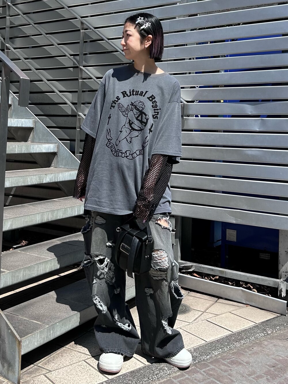 ブラック系のショルダーバッグ、ブラック系のデニムパンツ、グレー系のTシャツ/カットソーを着用したレディースの春コーディネートの3枚目の写真