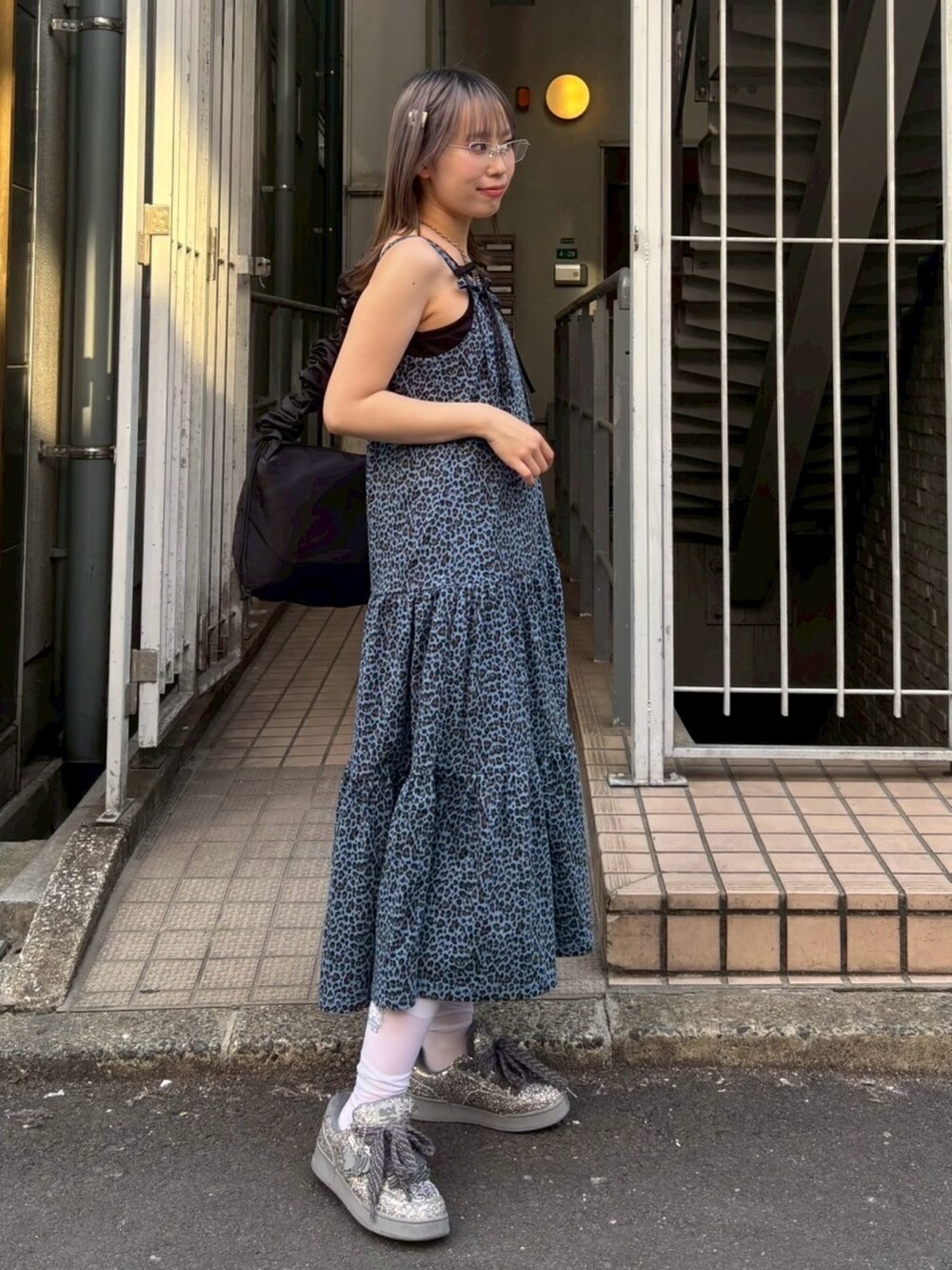 ブラック系のショルダーバッグ、ブラック系のキャミソール、ブルー系のワンピースを着用したレディースの春コーディネートの4枚目の写真