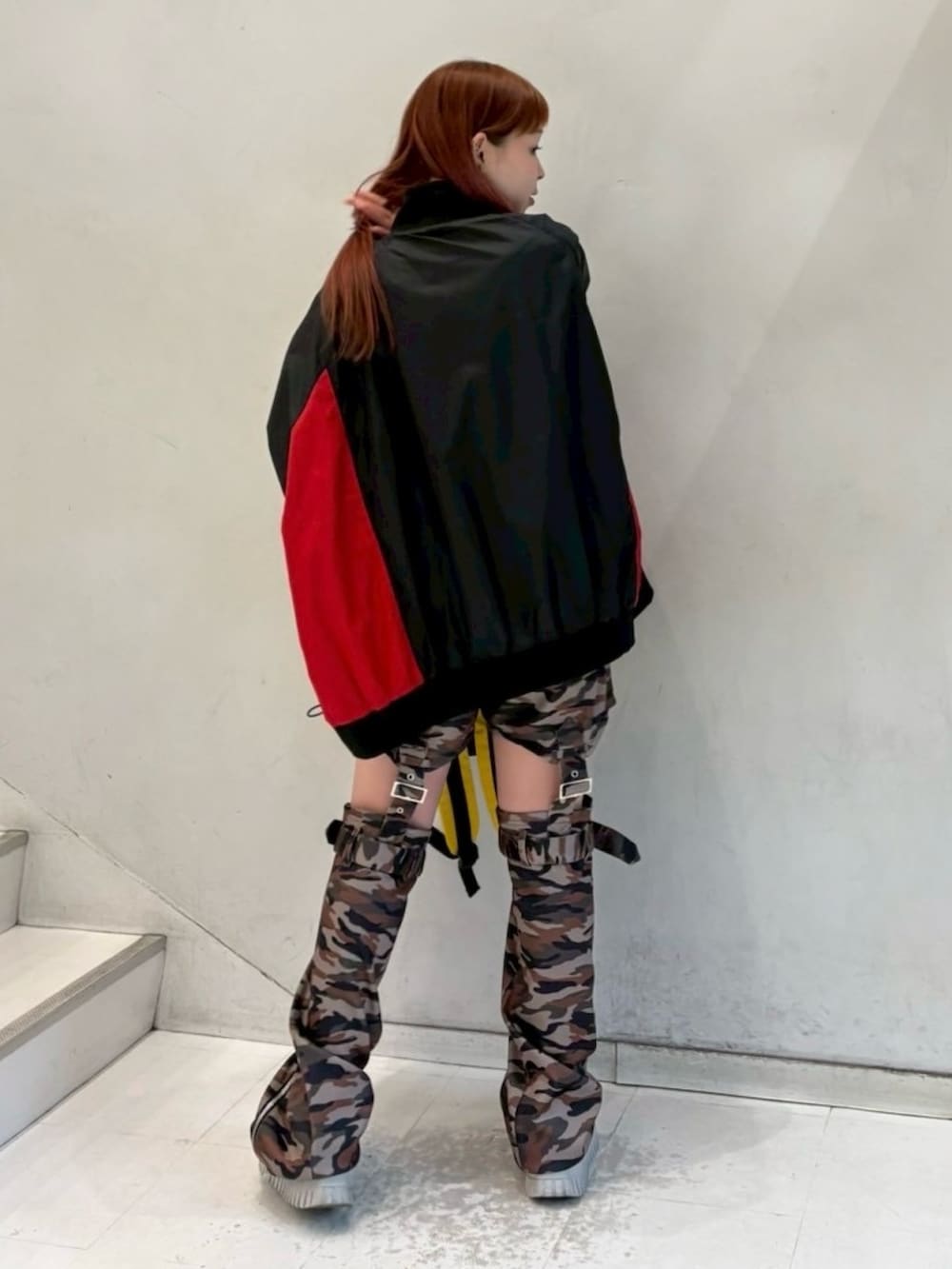 ブラック系のナイロンジャケット、グリーン系のその他パンツ、レッド系のバックパック/リュックを着用したレディースの秋コーディネートの5枚目の写真