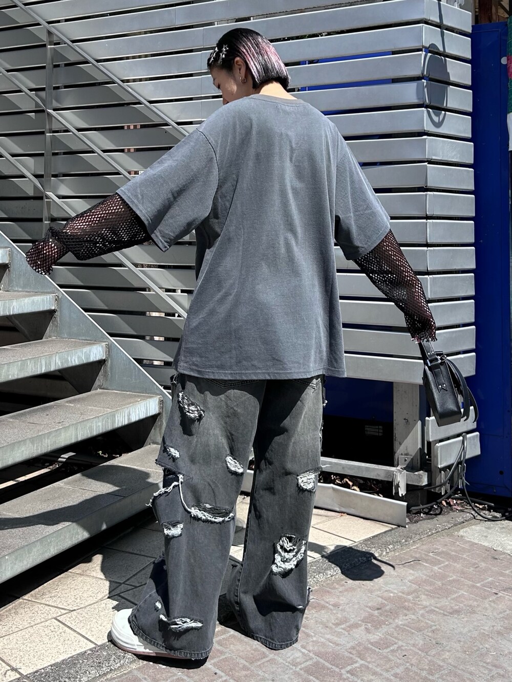 ブラック系のショルダーバッグ、ブラック系のデニムパンツ、グレー系のTシャツ/カットソーを着用したレディースの春コーディネートの5枚目の写真