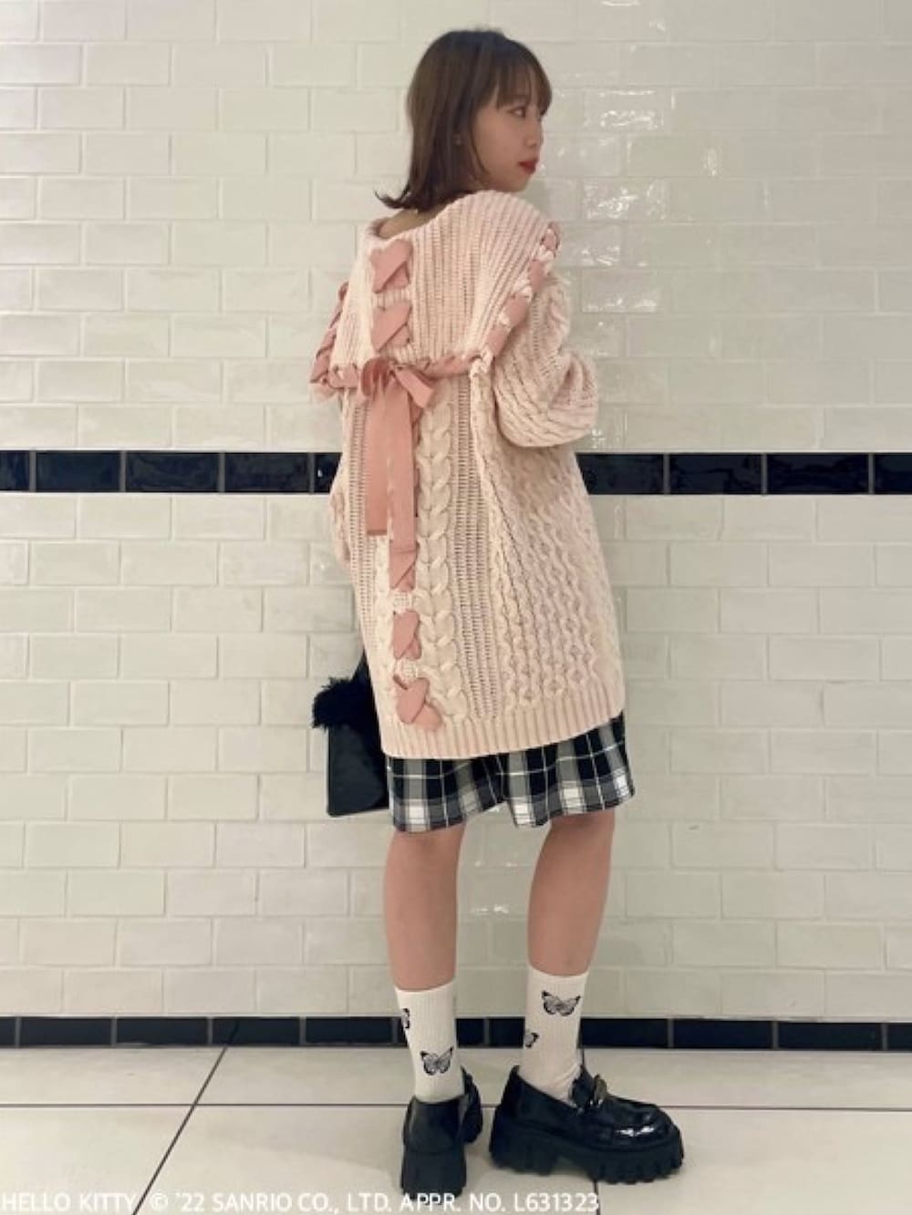 ピンク系のニット/セーター、ブラック系のその他パンツ、ブラック系のハンドバッグを着用したレディースの秋コーディネートの2枚目の写真