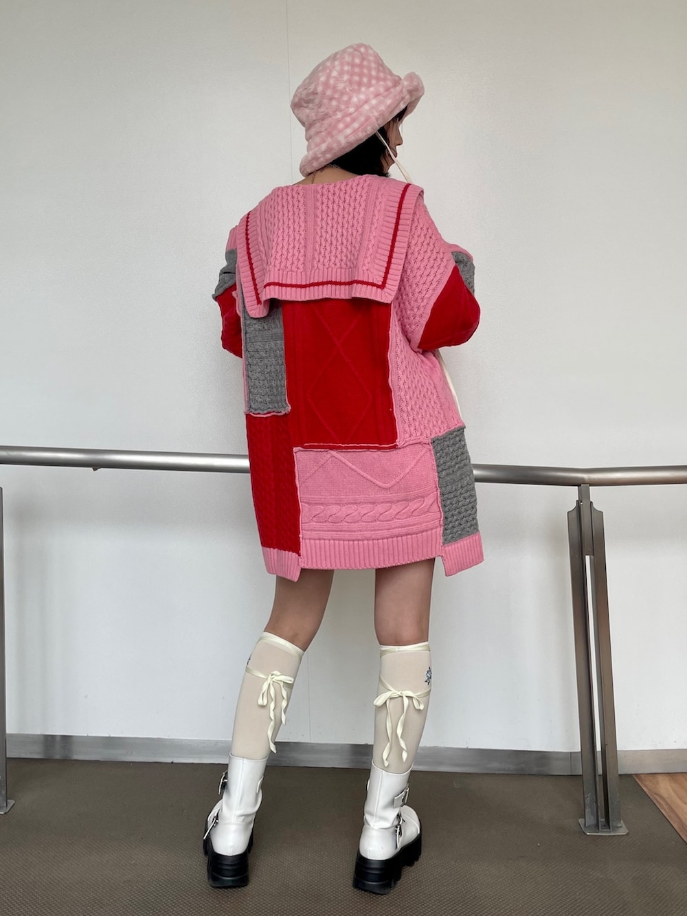 ピンク系のニット/セーター、ホワイト系のその他パンツ、ホワイト系のブーツを着用したレディースの秋コーディネートの4枚目の写真