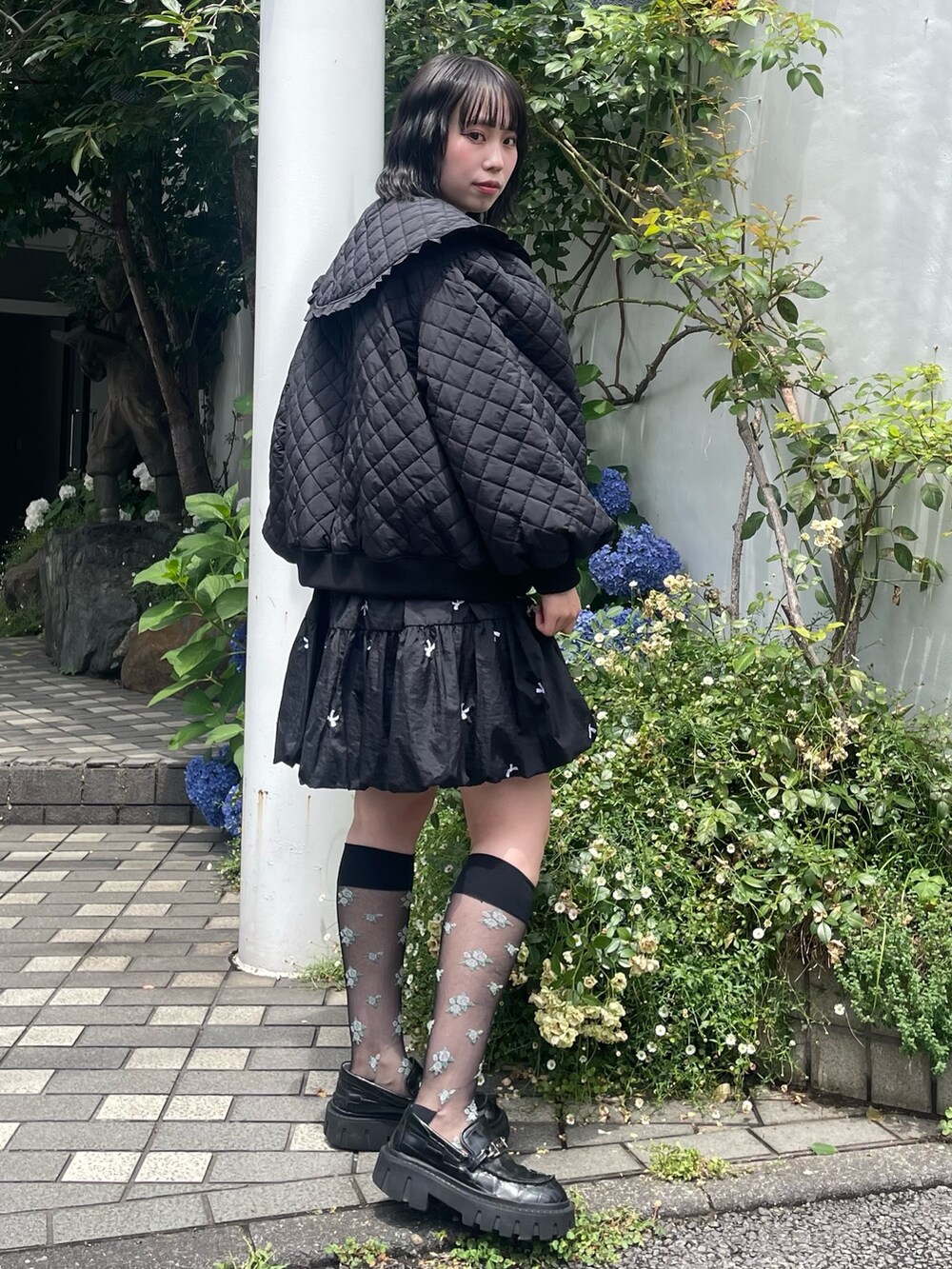 ブラック系のスカート、ブラック系のその他アウター、ブラック系のローファーを着用したレディースの冬コーディネートの2枚目の写真