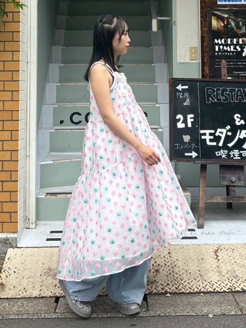 ピンク系のワンピース、ホワイト系のキャミソール、ブルー系のデニムパンツを着用したレディースの夏コーディネートの3枚目の写真