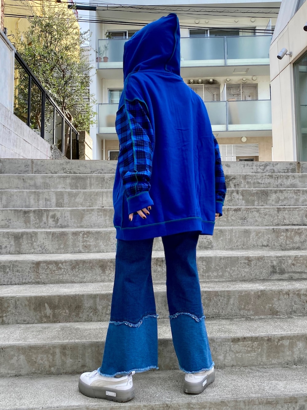 ブルー系のパーカー、ブルー系のデニムパンツを着用したレディースの冬コーディネートの3枚目の写真