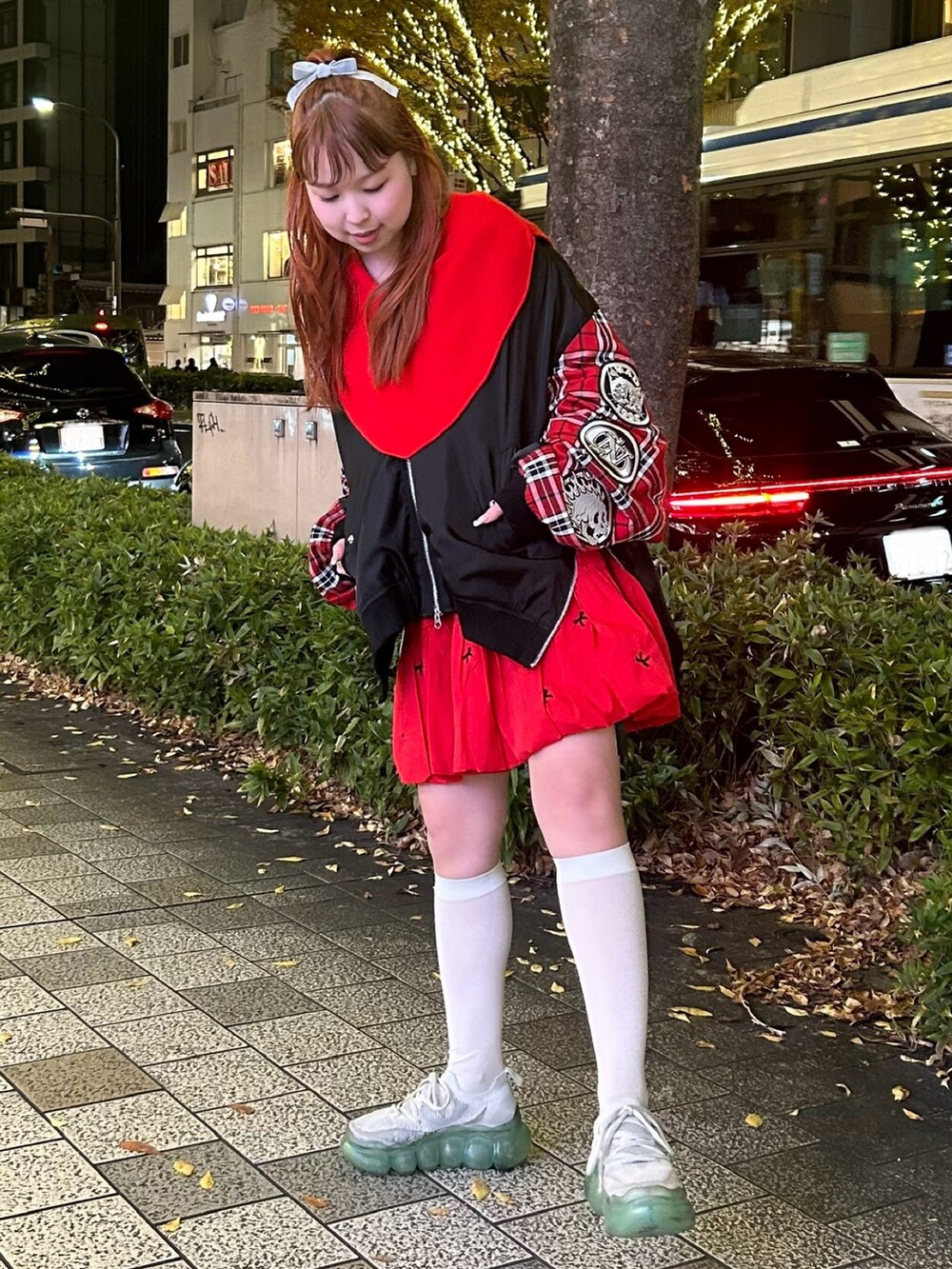 レッド系のスカート、ブラック系のMA-1、レッド系のニット/セーターを着用したレディースの冬コーディネートの2枚目の写真